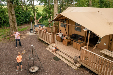 Familie ontspant en speelt bij een safari glampingtent op Buitengoed Ruysbos, Nederland.