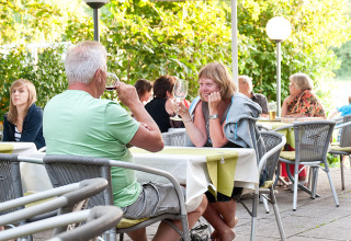 Udendørs restaurantområde på Camping Heidehof - Glamping Baden-Württemberg med gæster, der nyder drikkevarer.