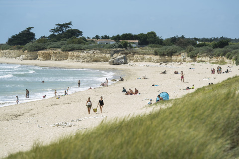 Glamping Huttopia Côte Sauvage - Ile de Ré in Nouvelle-Aquitaine met gasten op het zandstrand aan zee.