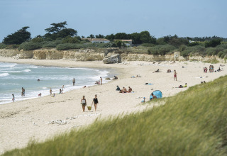 Glamping Huttopia Côte Sauvage - Ile de Ré in Nouvelle-Aquitaine met gasten op het zandstrand aan zee.