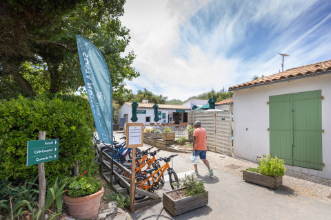 Un uomo passa vicino a biciclette presso Huttopia Côte Sauvage - Ile de Ré, glamping in Nouvelle-Aquitaine, Francia.