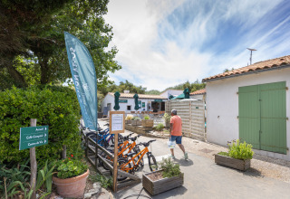 Mand går forbi cykler ved Huttopia Côte Sauvage - Ile de Ré glampingplads i Nouvelle-Aquitaine, Frankrig.