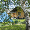 Glamping in a safari tent at Boerderij De Boerinn, Utrecht, Netherlands, surrounded by greenery and trees.