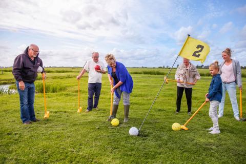 Familie geniet van een leuk buitenspel met grote ballen bij Boerderij De Boerinn – Safaritenten Utrecht kampeerplek.