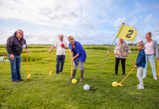 Familie genießt ein einzigartiges Outdoor-Spiel mit großen Bällen bei Boerderij De Boerinn – Safaritenten Utrecht.