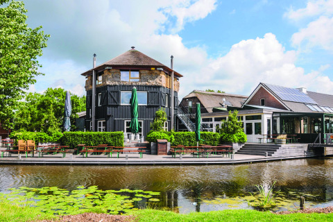 Boerderij De Boerinn in Utrecht, Glamping-Unterkunft am Wasser mit Sitzbereich und moderner Architektur.
