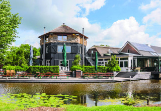 Boerderij De Boerinn, alojamiento de glamping en Utrecht junto a un estanque, mesas exteriores y vegetación.