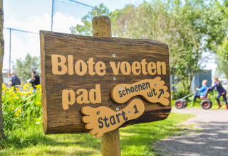 Houten bord bij Boerderij De Boerinn – Safaritenten Utrecht, start van het blotevoetenpad voor gasten.
