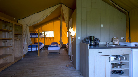 Interno di alloggio glamping presso Boerderij De Boerinn – Safaritenten Utrecht con cucina e letti.