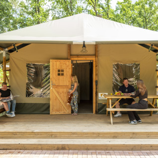 Familie geniet op het terras van een glampingtent aan de Serengeti Park Tongasoa Lodges, Nedersaksen.