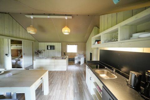 Bright interior of a glamping accommodation at Serengeti Park - Tongasoa Lodges, Niedersachsen, with kitchen area.