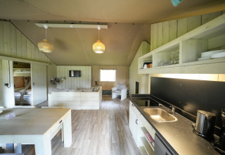 Licht interieur van een glampingaccommodatie bij Serengeti Park - Tongasoa Lodges, Nedersaksen, met keukenruimte.