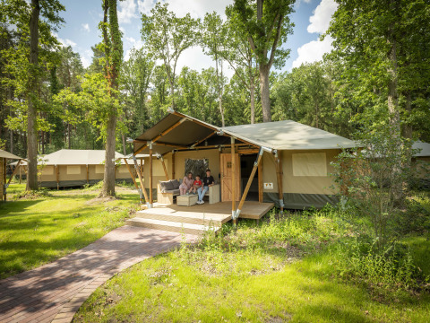 Familie op de veranda van een glamping tent bij Serengeti Park - Tongasoa Lodges, omgeven door natuur, Nedersaksen.