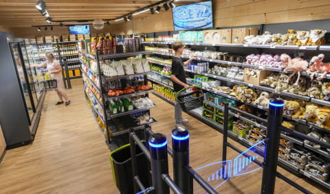 Zone d’achats au Serengeti Park - Tongasoa Lodges, Basse-Saxe, avec visiteurs choisissant produits et peluches.