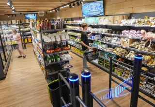 Shopping area at Serengeti Park - Tongasoa Lodges, Lower Saxony, with visitors selecting groceries and plush toys.