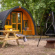 Lille hytte Boshuys Ultra Wellness med bænkesæt og bålplads blandt træer ved Buitengoed Ruysbos, Holland.