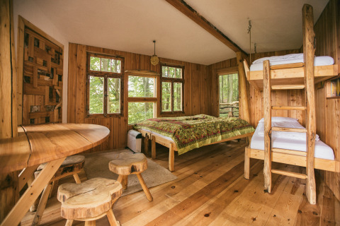 Intérieur glamping tout en bois de Baumhausherberge Robins Nest Boomhutten Hessen avec lits superposés et double.