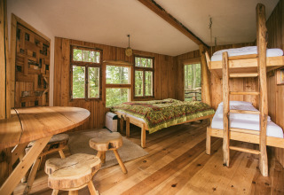 Intérieur glamping tout en bois de Baumhausherberge Robins Nest Boomhutten Hessen avec lits superposés et double.