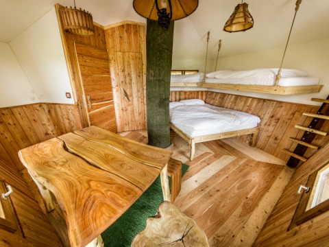 Alloggio glamping rustico in legno con letto sospeso, Baumhausherberge Robins Nest, Boomhutten Hessen.