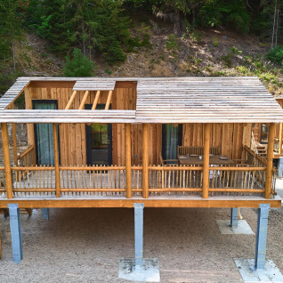 Boomhutten op palen in een bosrijke heuvel, glamping bij UplandParcs Sauerland, Noordrijn-Westfalen.