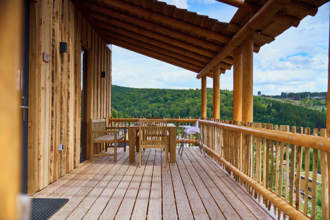 Boomhut met overdekt terras en uitzicht op groene heuvels bij UplandParcs Sauerland Boomhutten.