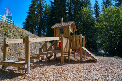 Parco giochi con casetta in legno e ponte sospeso a UplandParcs Sauerland - Boomhutten glamping in Renania Settentrionale-Vestfalia.
