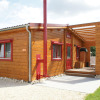 Wooden bungalow with red trim at Camping & Vakantiepark Orsingen, Baden-Württemberg, ideal for glamping stays.