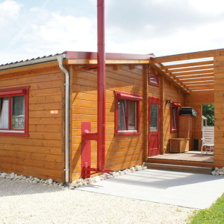 Bungalow in legno con infissi rossi al Camping & Vakantiepark Orsingen, Baden-Württemberg, ideale per glamping.