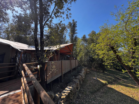 Hébergement glamping en tente avec terrasse en bois dans la forêt à l’Agriturismo & Glamping Serraiola Alta, Toscane.