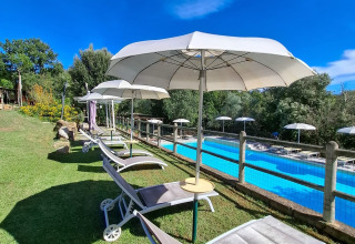Sun loungers and umbrellas by the pool at Agriturismo & Glamping Serraiola Alta – Glamping tents in Tuscany.