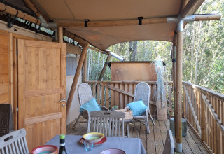 Terrasse en bois avec table dressée au Agriturismo & Glamping Serraiola Alta, tente lodge en Toscane, Italie.