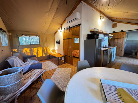 Vista interior de una tienda glamping de lujo en Agriturismo & Glamping Serraiola Alta, con cocina y salón.