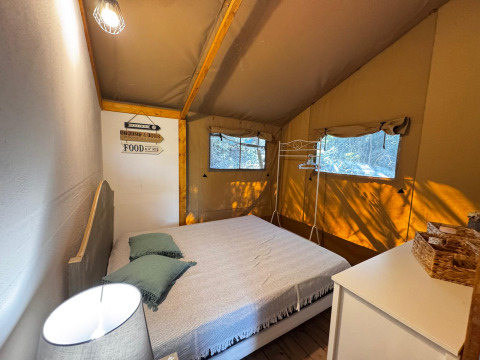 Camera da letto in tenda glamping presso Agriturismo & Glamping Serraiola Alta con letto matrimoniale e natura.