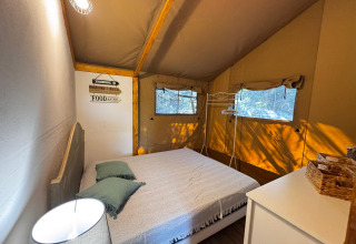 Chambre sous tente glamping à Agriturismo & Glamping Serraiola Alta avec lit double et vue sur la nature.