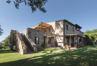 Stenen huis met buitentrap en terrassen bij Agriturismo & Glamping Serraiola Alta, Toscane, Italië.