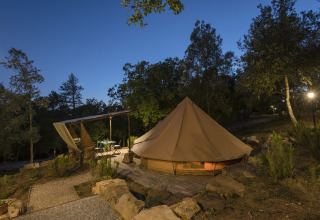 Alojamiento glamping en Agriturismo & Glamping Serraiola Alta en la Toscana con tienda y zona al aire libre al anochecer.