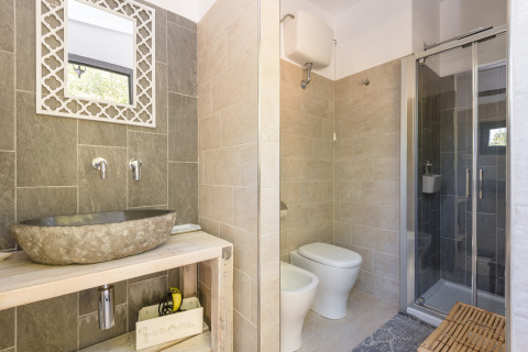 Modern bathroom at Agriturismo & Glamping Serraiola Alta, stone sink, bidet and shower, Tuscany glamping tent.
