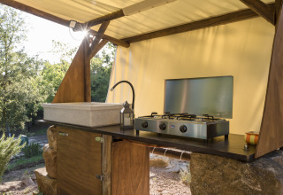 Outdoor kitchen at Agriturismo & Glamping Serraiola Alta with sink and gas stove, set in Tuscan nature.