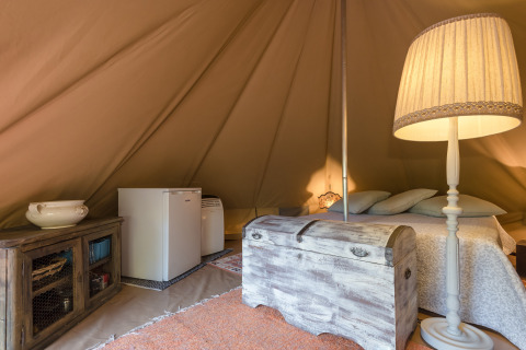Interieur van een glampingtent bij Agriturismo & Glamping Serraiola Alta, Toscane, met bed en koelkast.