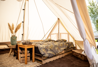 Gemütliche Glamping-Unterkunft im Landgoed Lindehof – Glamp Lodges Friesland mit bequemen Bett im Zelt.