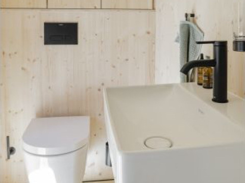 Moderne badeværelse i glampingindkvartering Ostsee Baumhaus nær Østersøen med toilet og håndvask.