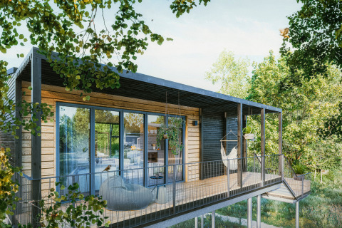 Moderne boomhut glamping aan de Oostzee in Sleeswijk-Holstein met ruim terras en hangstoel in de natuur.