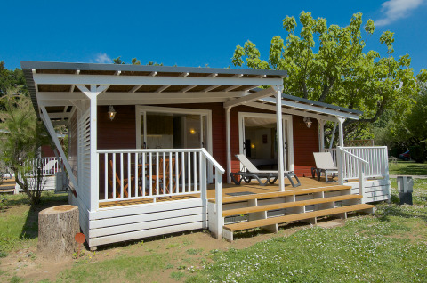 Glamping al Camping Nature Parc l'Ardéchois, cabina moderna con veranda immersa nella natura dell'Ardèche.
