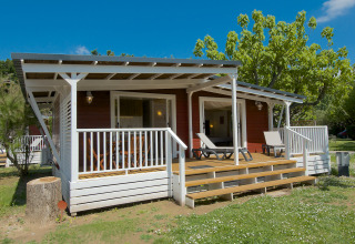 Glamping al Camping Nature Parc l'Ardéchois, cabina moderna con veranda immersa nella natura dell'Ardèche.