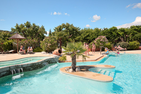 Piscina e ospiti rilassati presso Camping Nature Parc l'Ardéchois - Glamping Ardèche in un ambiente soleggiato.