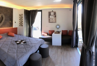 Hébergement glamping avec chambre élégante, déco chaleureuse et terrasse privée au Parc Naturel Ardèche.