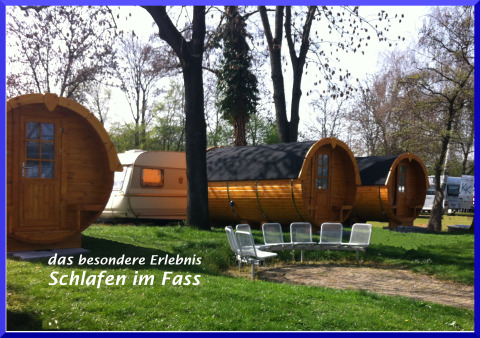 Casette di legno a forma di botte e roulotte al Camping Stuttgart Cannstatter Wasen in Baden-Württemberg.