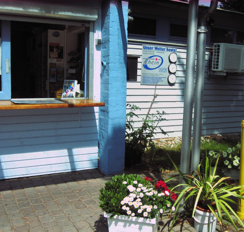 Reception ved glamping- eller campingpladsen Camping Stuttgart Cannstatter Wasen med blomsterpotter foran.