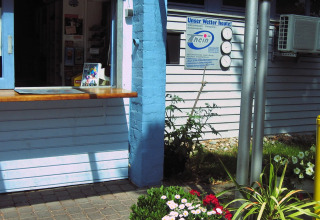 Reception ved glamping- eller campingpladsen Camping Stuttgart Cannstatter Wasen med blomsterpotter foran.