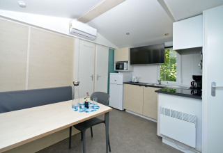 Moderne glampingbolig på Drau Camping Sachsenburg med køkken, spisebord og fladskærms-TV i Karintien.